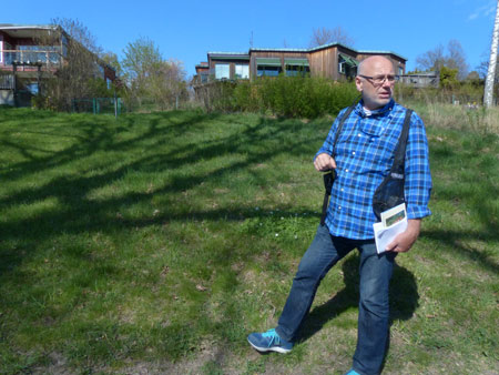 Christer Wik, Lidingös stadsantikvarie, ledde den kunskapsfyllda vandringen. Här står han nedanför husen på Boholmsstigen.