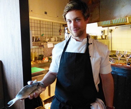 Grill Brunos restaurangchef August Odervall visar upp en dorade, en fisk som grillas med huvudet kvar.